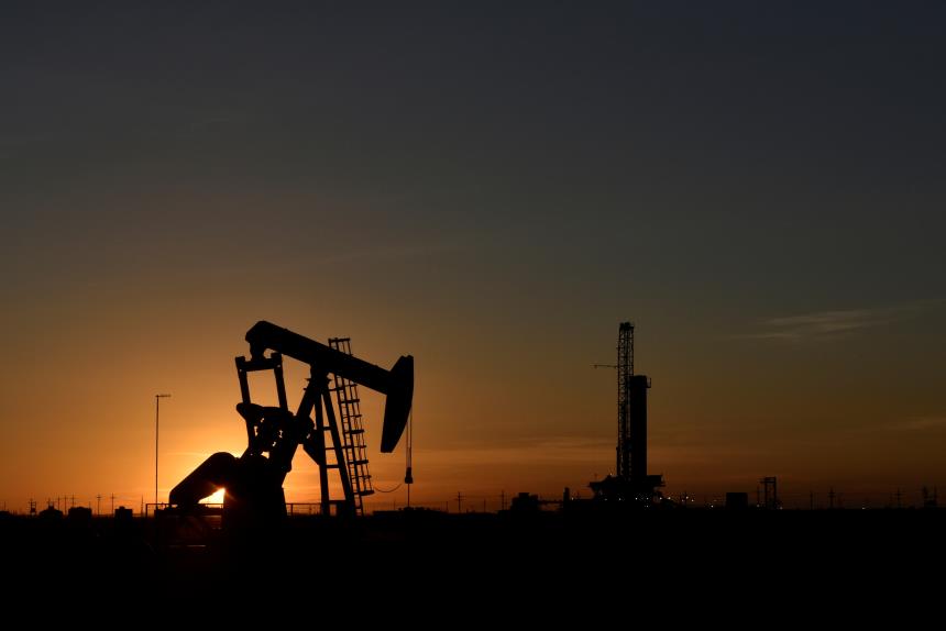 A pump jack operates in front of a drilling rig at sunset in an oil field in Midland, Texas U.S. August 22, 2018. REUTERS/Nick Oxford