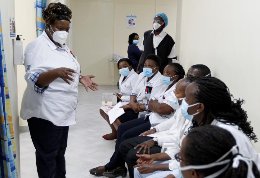 A health worker talks to her colleagues as they prepare to receive the AstraZeneca/Oxford vaccine under the COVAX scheme against coro<em></em>navirus disease (COVID-19) at the Kenyatta Natio<em></em>nal Hospital in Nairobi, Kenya March 5, 2021. REUTERS/Mo<em></em>nicah Mwangi/File Photo