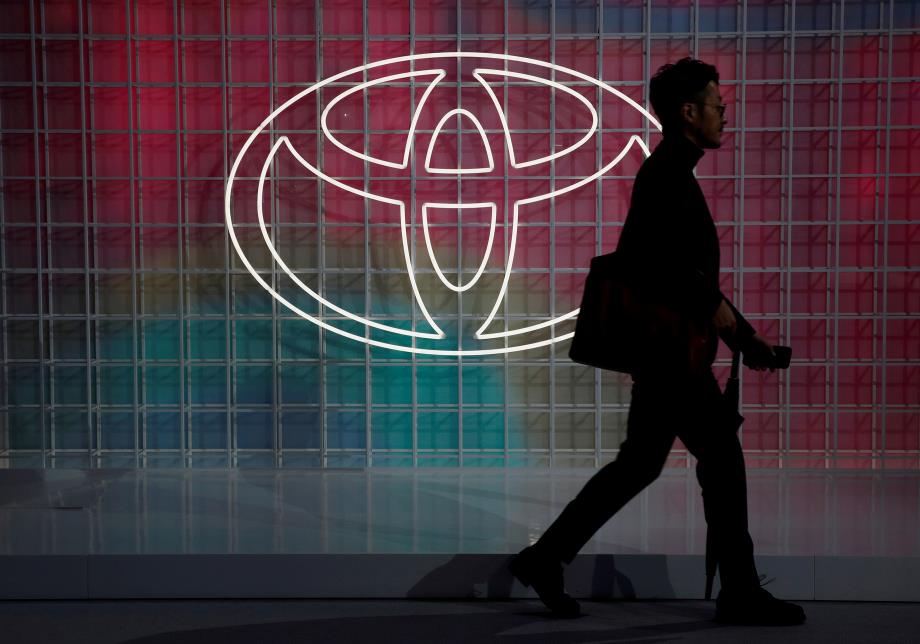 A man walks past a Toyota logo at the Tokyo Motor Show, in Tokyo, Japan October 24, 2019. REUTERS/Edgar Su/File Photo