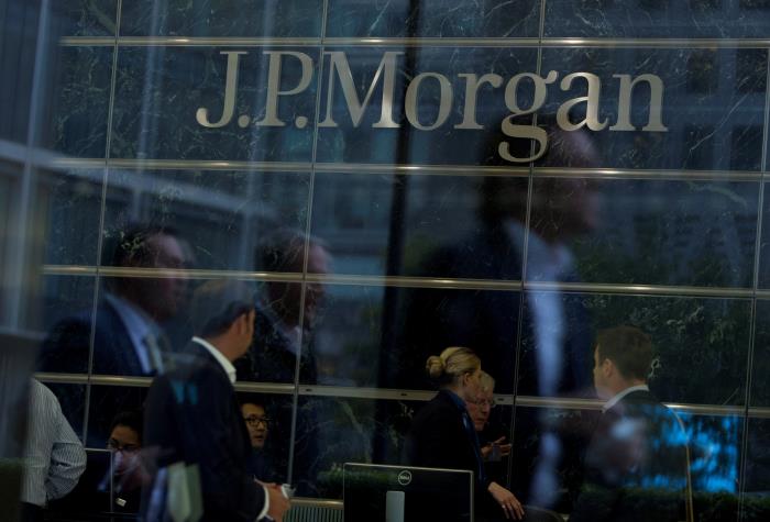 Workers are reflected in the windows of the Canary Wharf offices of JP Morgan in Lo<em></em>ndon September 19, 2013. REUTERS/Neil Hall/File Photo