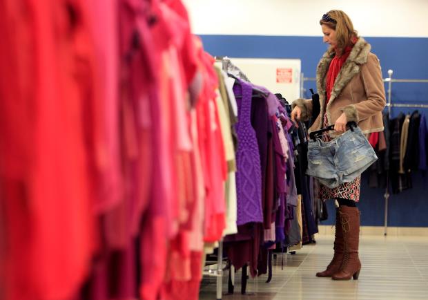 A customer looks at clothes on display at a store of a major second hand clothes importer in Hungary, in Budapest November 5, 2014. REUTERS/Bernadett Szabo/File Photo