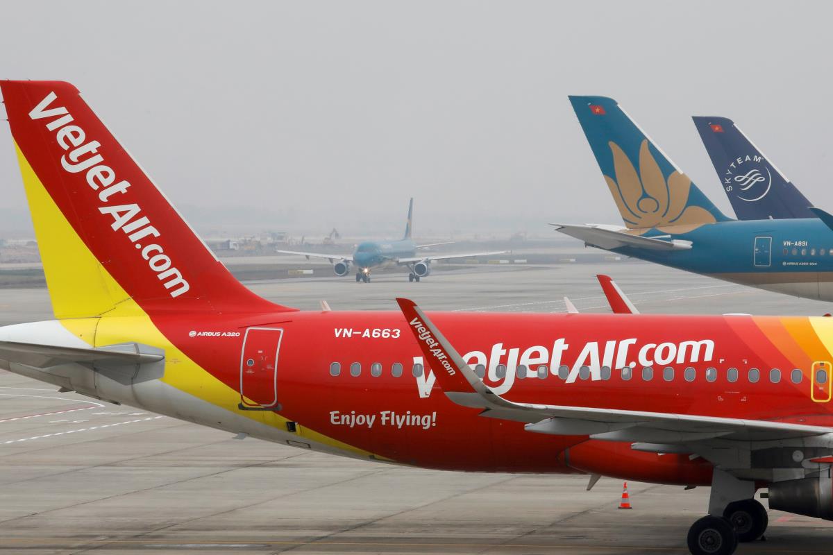 An aircraft of the natio<em></em>nal flag carrier Vietnam Airlines taxis behind a Vietjet aircraft at Noi Bai airport in Hanoi, Vietnam December 23, 2020. Picture taken December 23, 2020. REUTERS/Kham