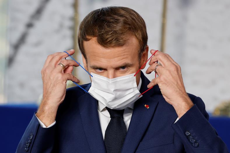 French President Emmanuel Macron adjusts his protective face mask at the start of the G20 leaders summit at the co<em></em>nvention center La Nuvola in Rome, Italy, October 30, 2021. Ludovic Marin/Pool via REUTERS/File Photo