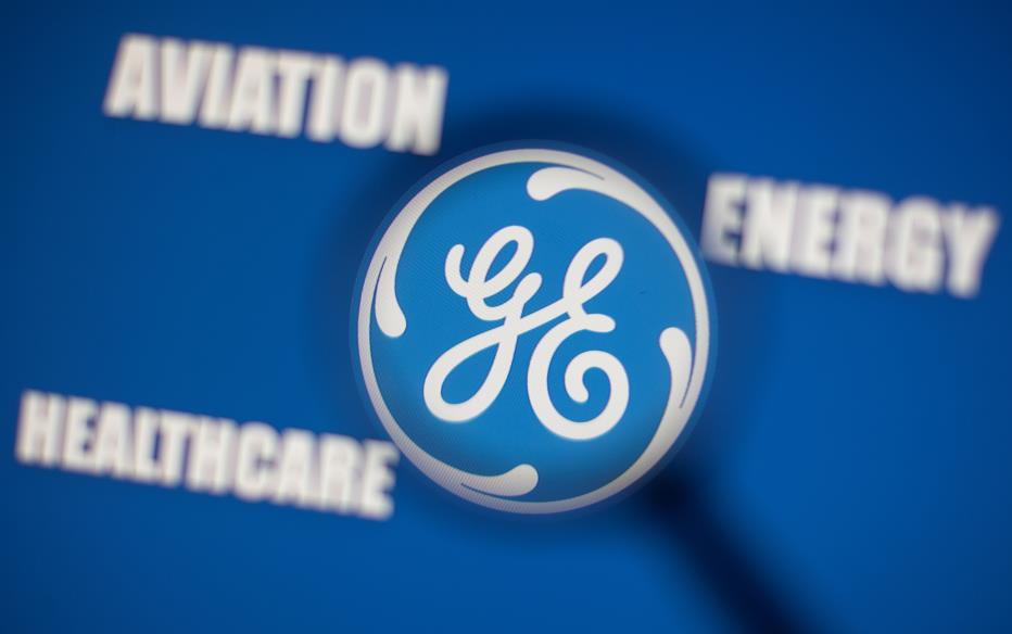 General Electric logo is seen through magnifier in front of displayed Aviation, Energy, Healthcare words in this illustration taken, November 9, 2021. REUTERS/Dado Ruvic/Illustration