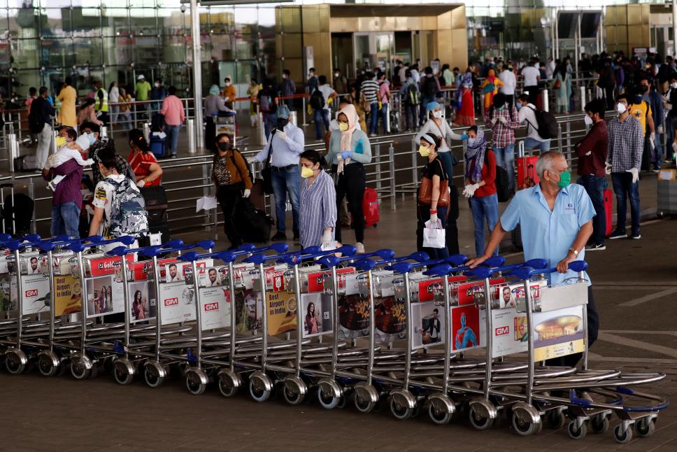 An airport staff member pushes trollies at the entrance of Chhatrapati Shivaji Internatio<em></em>nal Airport, after the government allowed domestic flight services to resume, during an extended natio<em></em>nwide lockdown to slow the spread of the coro<em></em>navirus disease (COVID-19), in Mumbai, India, May 25, 2020. REUTERS/Francis Mascarenhas