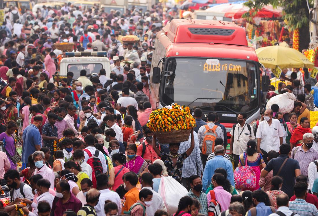 A man carrying flower garlands walks through a crowded market ahead of the religious festival of Dussehra, amidst the spread of the coro<em></em>navirus disease (COVID-19) in Mumbai, India, October 14, 2021. REUTERS/Francis Mascarenhas