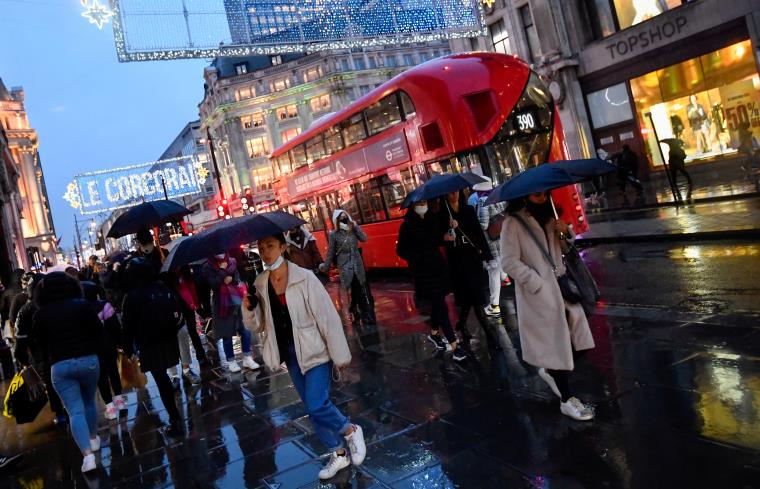 Shoppers hold umbrellas as they walk, following the outbreak of the coro<em></em>navirus disease (COVID-19), at Oxford Street in London, Britain December 16, 2020. REUTERS/Toby Melville/File Photo  GLOBAL BUSINESS WEEK AHEAD