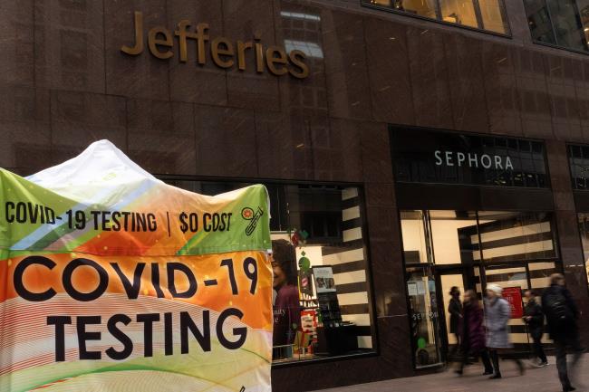 People walk past a COVID-19 testing tent outside the Jefferies Financial Group offices in Manhattan, New York City, U.S., December 8, 2021. REUTERS/Eduardo Munoz