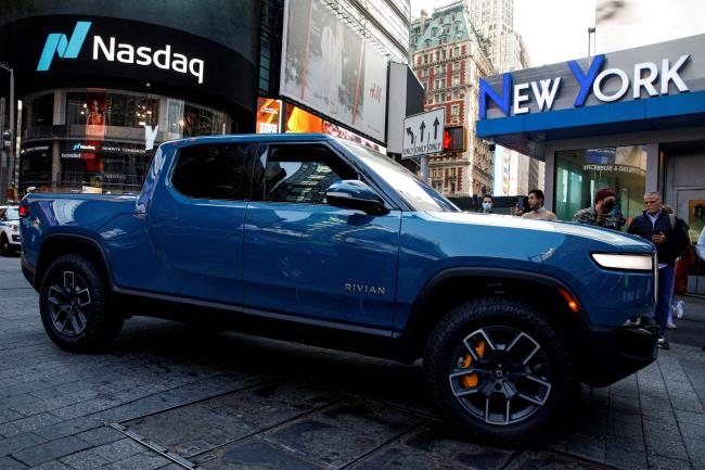 A Rivian R1T pickup, the Amazon-backed electric vehicle (EV) maker, is driven outside the Nasdaq Market site during the company’s IPO in Times Square in New York City, U.S., November 10, 2021.  REUTERS/Brendan McDermid/File Photo