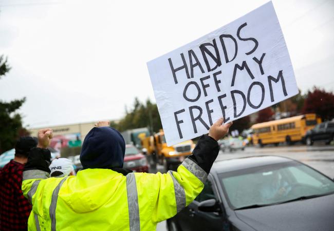 A protester gestures at passing traffic as Boeing employees and others line the street to protest the company's coro<em></em>navirus disease (COVID-19) vaccine mandate, outside the Boeing facility in Everett, Washington, October 15, 2021.  REUTERS/Lindsey Wasson