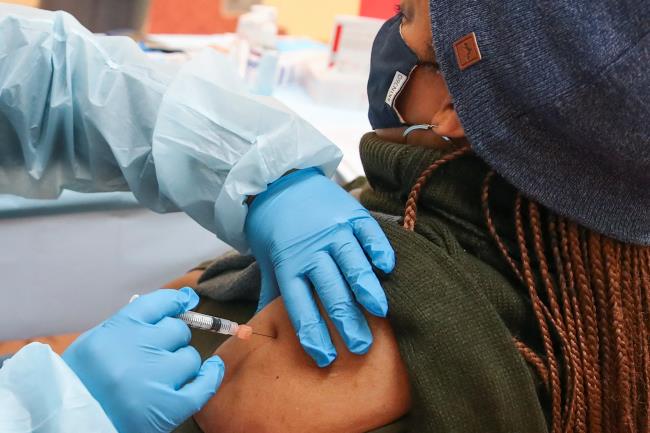 FILE PHOTOKim Ingram (R) receives the Moderna coro<em></em>navirus disease (COVID-19) vaccination shot from nurse Kenya Gunn (L) at Trinity United Church of Christ in Chicago, Illinois, U.S., February 13, 2021.  REUTERS/Kamil Krzaczynski