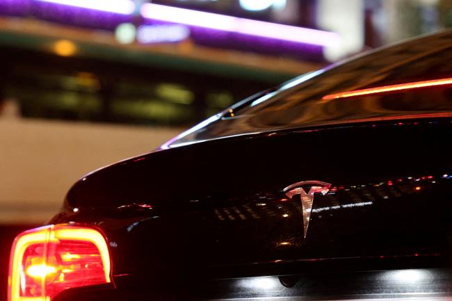 A Tesla logo is seen on a Parisian taxi car in Paris, France, December 14, 2021. REUTERS/Sarah Meyssonnier/File Photo