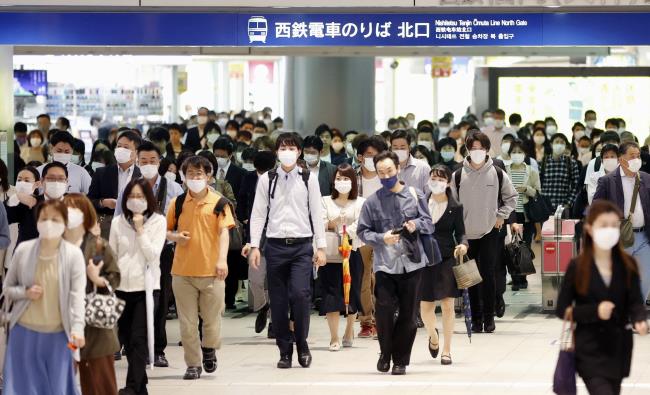 Commuters wearing protective face masks are seen a day after the government announced the lifting of the state of emergency by the coro<em></em>navirus disease (COVID-19) in large parts of the country including Fukuoka, in Fukuoka, southern Japan, in this photo taken by Kyodo May 15, 2020. Mandatory credit Kyodo/via REUTERS   