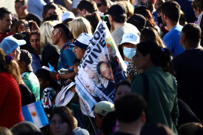 A supporter of Argentina's President Alberto Fernandez holds banners with the image of  Argentina's late former President Nestor Kirchner during Fernandez's closing campaign rally before midterm elections, in Merlo, Buenos Aires, Argentina, November 11, 2021. REUTERS/Matias Baglietto