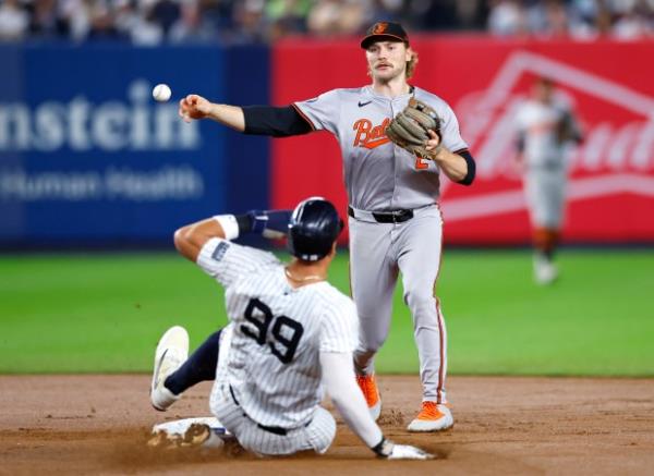 New York Yankees' Aaron Judge (99) is out on a force as Baltimore Orioles shortstop Gunnar Henderson, top, throws the double play ball hit by Austin Wells to first ba<em></em>se during the fourth inning of a ba<em></em>seball game, Thursday, Sept. 26, 2024, in New York. (AP Photo/Noah K. Murray)