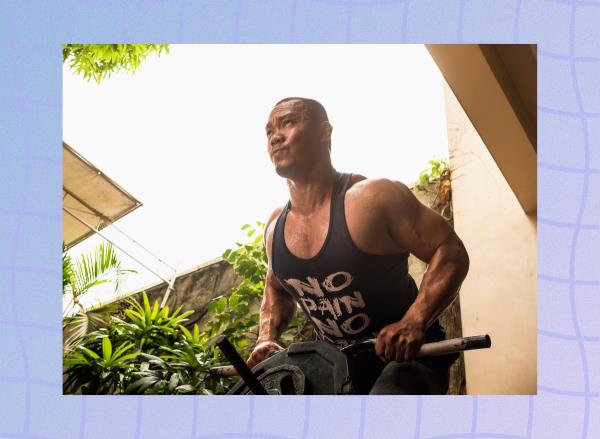 determined, muscular man doing T bar row outdoors