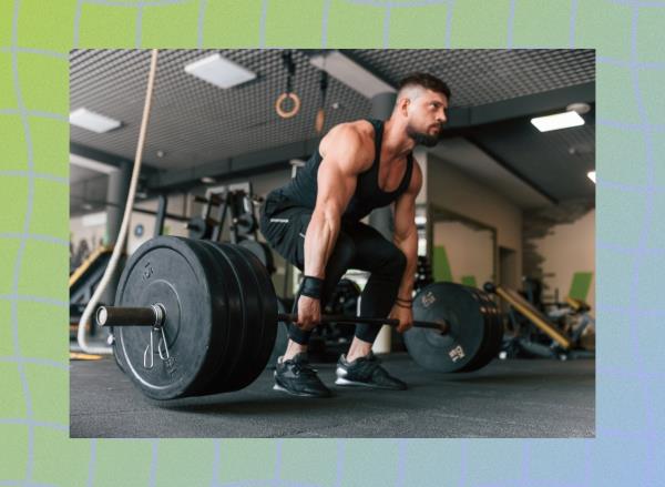 fit, muscular man doing a barbell deadlift with heavy weights at the gym