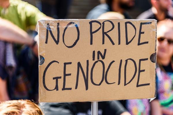 A cardboard sign that says no pride in genocide