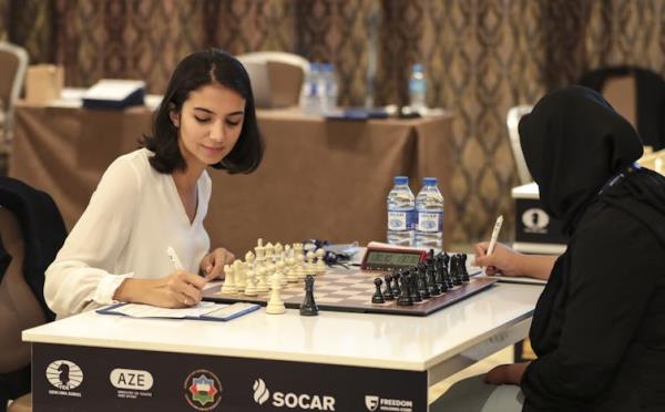 Sarah Khadem makes a note while playing chess opposite Indonesia's Medina Warda Aulia.