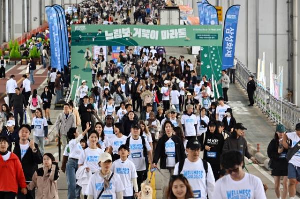 Participants of the Slow Marathon with Pets and their companion pets walk along the Jamsu Bridge -- a submersible bridge co<em></em>nnecting Yo<em></em>ngsan and Seocho -- on Sunday. (Park Hae-mook/The Korea Herald)