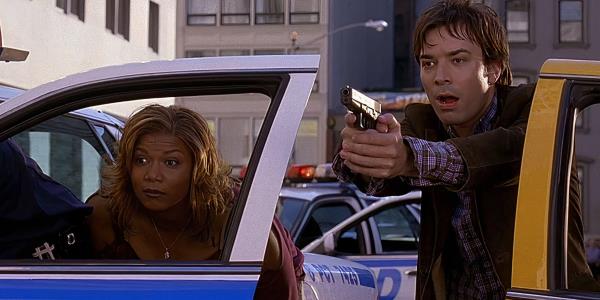 Queen Latifah's Belle and Jimmy Fallon's Washburn looking surprised while taking cover behind car doors in Taxi