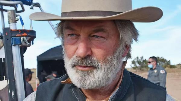 Alec Baldwin on the set of Rust wearing a cowboy hat looking off-screen