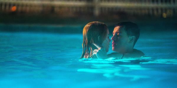 Romy and Samuel embracing in a pool in Babygirl