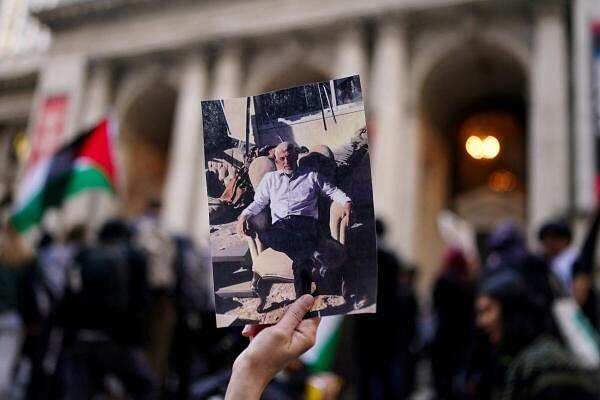 A person holds an image of Yahya Sinwar sitting on a chair during an “All Out for Palestine” protest against Israeli arms funding, at New York Public Library in New York City.