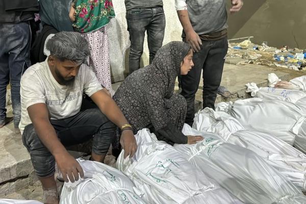 Palestinians at Kamal Adwan Hospital mourn over the bodies of relatives who were killed in an Israeli airstrike on northern Gaza's Beit Lahia, on Oct. 19, 2024.