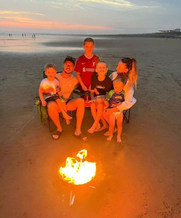 family pictured by fire on beach