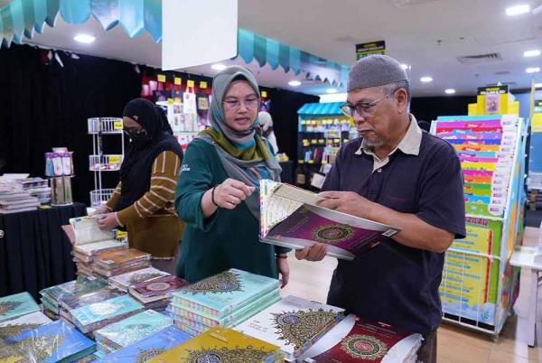 Karangkraf staff assisting visitors interested in purchasing the Quran.