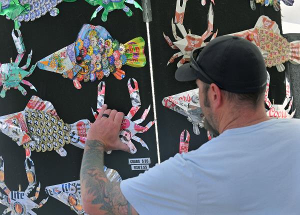 Artist Travis Edmisten, of Essex, replaces one of his Beer Cans Crab ornament that was sold at the 61st Havre de Grace Art Show on the waterfront at Tydings Memorial Parks. (Kenneth K. Lam/Staff)