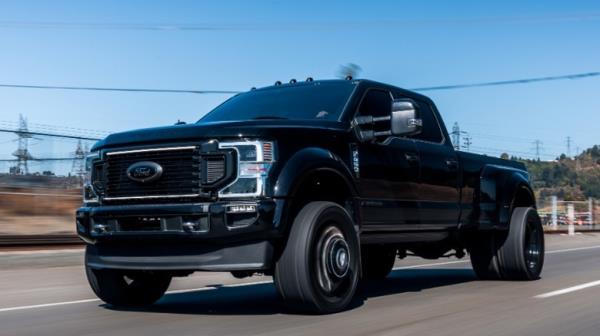 A person test driving a black Ford diesel pickup truck