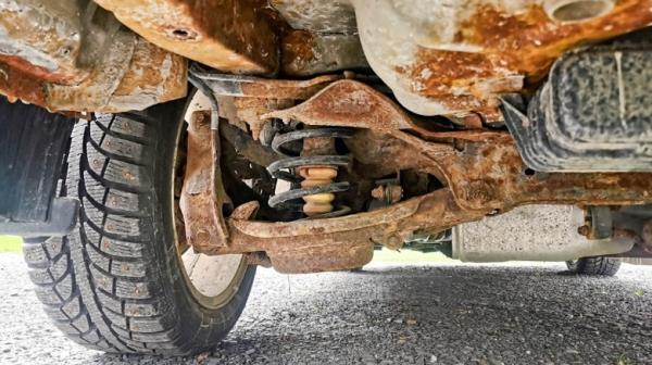 The bottom of a car with extensive rusting