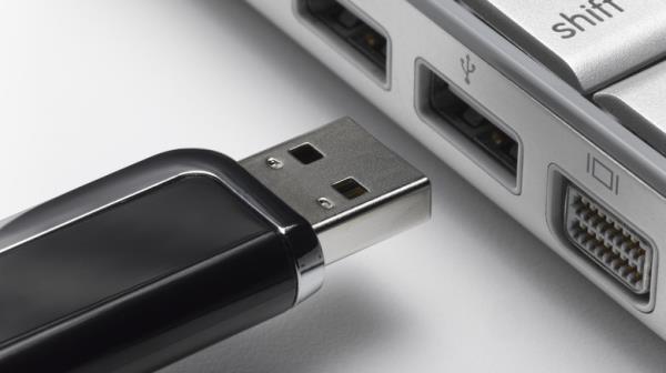 A flash drive being plugged into a USB port