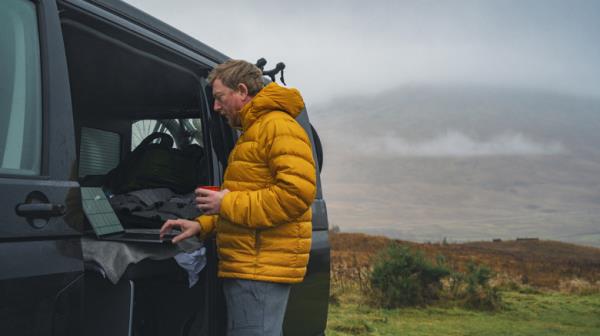 A man on a laptop in inclement weather