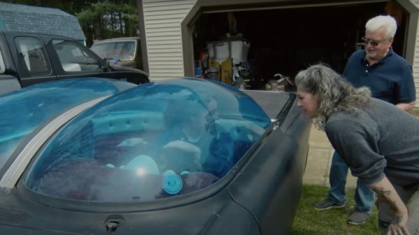 Danielle Colby peers in the window of an Ultimus bubble car at the driver's seat wher<em></em>e Mike Wolfe is sitting, while owner Rick Klibenski watches