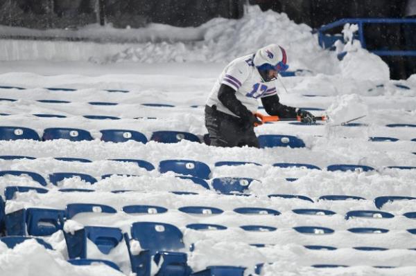 A Buffalo Bills fan shovels snow from seats before an NFL football game between the Bills and the San Francisco 49ers in Orchard Park, N.Y., Sunday, Dec. 1, 2024. (AP Photo/Adrian Kraus)