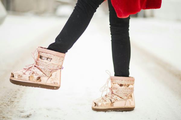 Pink boots seen on a snowy road.