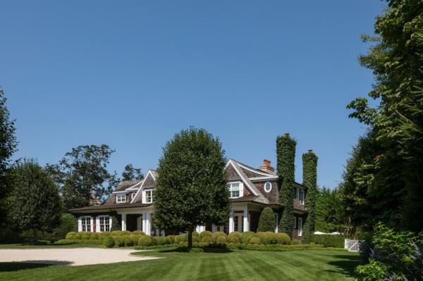 The shingled exterior stands on more than an acre of manicured grounds.