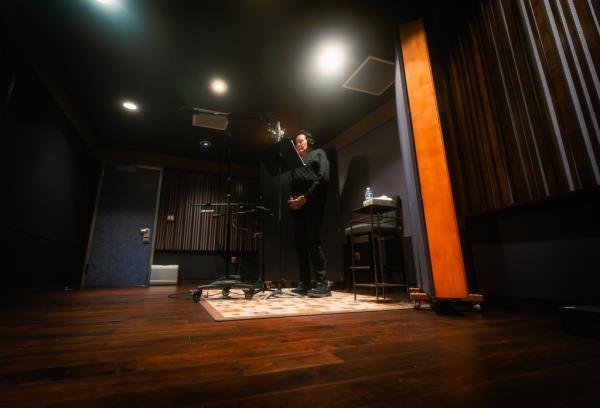 Wayne Newton standing on stage recording vocals for the song 'This Is America' inspired by the 'Reagan' biopic