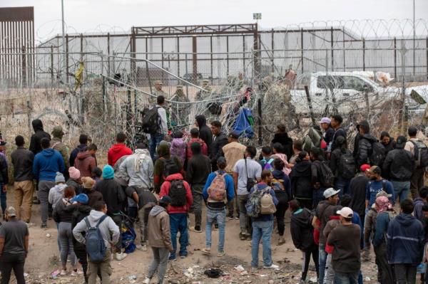 Migrant plead with the Texas Natio<em></em>nal Guard to be let in on the north embankment of the Rio Grande in El Paso, Texas in order to be processed by Border Patrol on March 20, 2024.