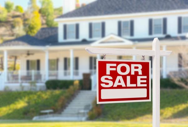 Home For Sale real estate sign in front of a beautiful new house