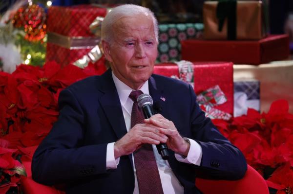 US President Joe Biden speaking into a microphone during a holiday visit at Children's Natio<em></em>nal Hospital in Washington, DC