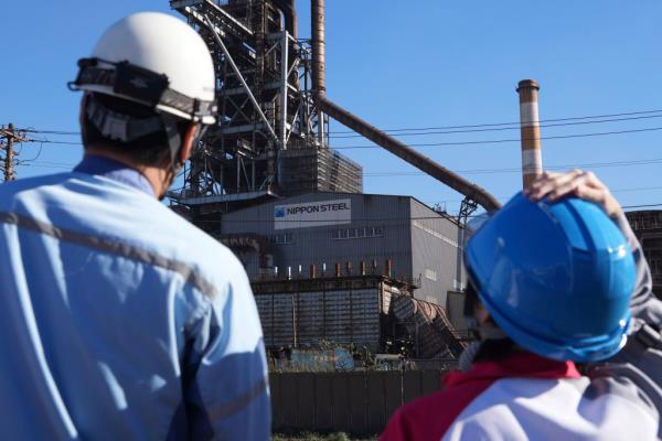 Exterior view of Blast Furnace No. 1 at Nippon Steel's Kashima Plant in Kashima, Japan with a group of helmeted people