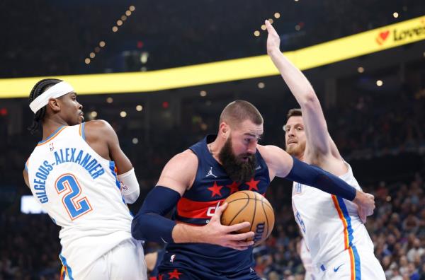 Washington Wizards center Jo<em></em>nas Valanciunas (17) pushes through Oklahoma City Thunder guard Shai Gilgeous-Alexander (2) and center Isaiah Hartenstein (55).