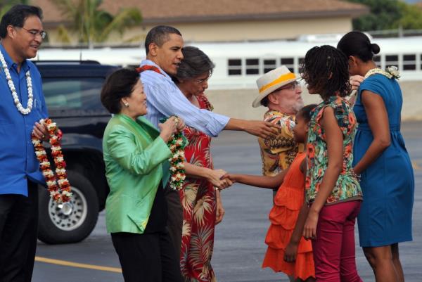 Barack and Michelle Obama, along with their daughters Malia and Sasha, being greeted traditio<em></em>nally upon disembarking Air Force One in Honolulu, Hawaii, for their Christmas vacation, 2009.