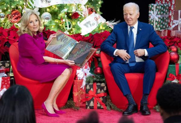 US President Joe Biden sits next to First Lady Jill Biden as she reads "'Twas The Night Before Christmas" during a holiday visit to patients and families at Children's Natio<em></em>nal Hospital in Washington, DC, on December 22, 2023. 