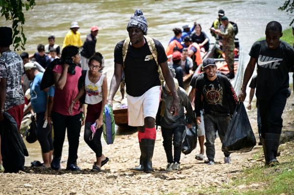 Migrants crossing near a river bank.