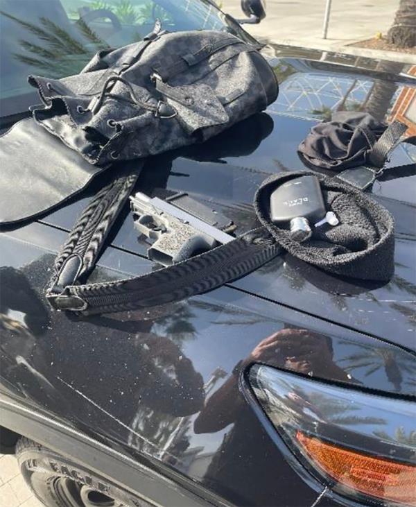 Black bag and a gun on a car hood symbolizing a law enforcement operation